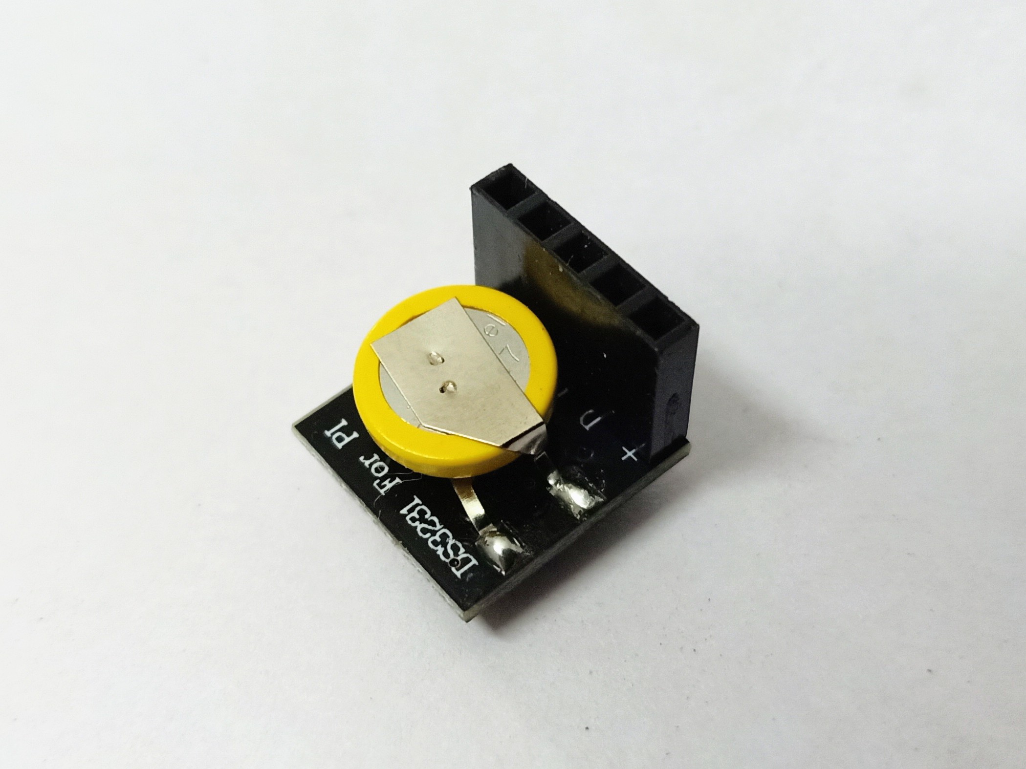 Figure 6 — A DS3231 real-time-clock breakout module, ~25 × 15 mm with a CR2032 coin cell on the rear. Four pins: VCC, GND, SDA, SCL — connect to the PicoCalc's 3 V3 + I²C bus on the side-header. Battery life:…