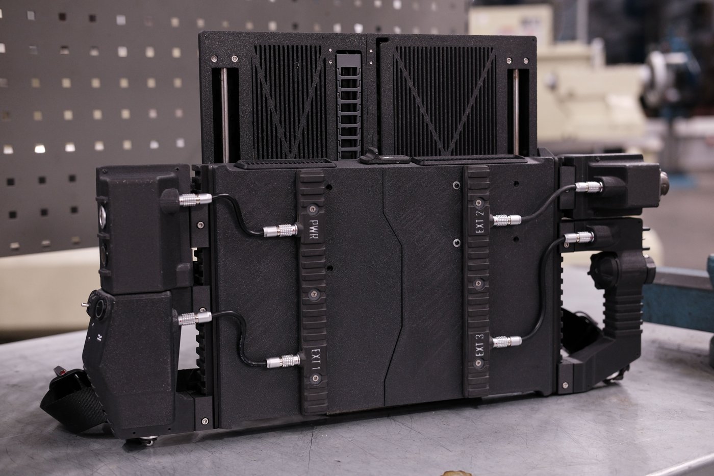 Figure 2 — 2 — Rear view of the DFCD: the self-locking power and signal connectors (PWR, EXT1–3), the drag-chain cable routing, and the printed cooling fins. Photo: ArcticEnrichmentCenter, DFCD proje…